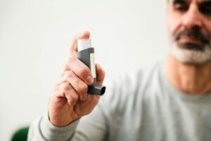 man using inhaler for respiratory health